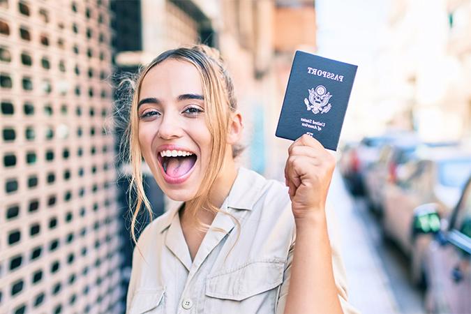 A woman holding up her passport.
